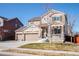 Charming two-story home with a covered porch, three-car garage, stone accents, and well-maintained landscaping at 30 Stewart Way, Erie, CO 80516