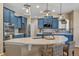 Stylish kitchen with blue cabinets, a large island with seating, modern appliances, and pendant lighting at 30 Stewart Way, Erie, CO 80516