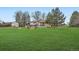 Expansive backyard featuring a well-maintained lawn and a charming house with a spacious deck at 5855 Rustic Knolls Dr, Boulder, CO 80301