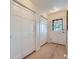 Hallway with multiple closets and a door featuring glass panes providing natural light at 5855 Rustic Knolls Dr, Boulder, CO 80301