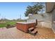 A wooden hot tub with steps, set on a paved patio next to a well-maintained lawn and fence at 5855 Rustic Knolls Dr, Boulder, CO 80301