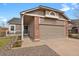 Charming single-Gathering home displaying an attached garage with brick and beige wood-look siding at 3844 S Gibralter St, Aurora, CO 80013