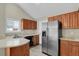 Efficient kitchen with stainless steel appliances, wood cabinetry, and ample counter space at 3844 S Gibralter St, Aurora, CO 80013