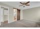 Carpeted main bedroom featuring ceiling fan, sliding barn door, and ensuite bathroom entrance at 3844 S Gibralter St, Aurora, CO 80013