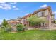 House exterior with a backyard patio, landscaping, and stone accents at 10443 Skyreach Way, Highlands Ranch, CO 80126