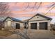 This home has a large driveway and a three car garage with dark carriage doors and stone details at 14642 Sorrel Dr, Broomfield, CO 80023