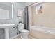 Well-lit bathroom with a sink, toilet, tub, and a view to the outside at 1630 N Clarkson St # 110, Denver, CO 80218