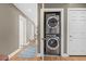 Hallway with laundry closet containing a stacked washer and dryer unit at 1630 N Clarkson St # 110, Denver, CO 80218