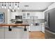 Bright kitchen showcasing stainless steel appliances, white cabinets, a farmhouse sink, and a wooden bar on the island at 1630 N Clarkson St # 110, Denver, CO 80218