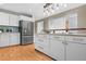 Bright kitchen with a large island with a wooden bar top, stainless steel appliances, and modern white cabinets at 1630 N Clarkson St # 110, Denver, CO 80218