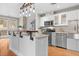 Modern kitchen featuring a stylish island with a wooden bar top, stainless steel appliances, and sleek white cabinetry at 1630 N Clarkson St # 110, Denver, CO 80218