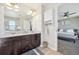 Bathroom features a dual sink vanity with dark cabinets and a view into the bedroom at 7902 E 49Th Pl, Denver, CO 80238