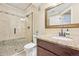 Well-lit bathroom with a granite countertop, tiled shower with glass door, and pebble stone accents at 7902 E 49Th Pl, Denver, CO 80238