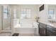 Relaxing bathroom featuring a soaking tub, glass shower, and elegant granite vanity at 7902 E 49Th Pl, Denver, CO 80238