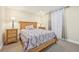 Cozy bedroom showcasing a wooden bed frame, matching bedside tables, and soft, natural light from the window at 7902 E 49Th Pl, Denver, CO 80238