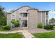 Multi-level condo building featuring stone and siding, plus mature landscaping at 8378 S Upham Way # B205, Littleton, CO 80128