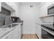 Modern kitchen featuring white cabinets, granite countertops, and stainless steel appliances at 3663 S Sheridan Blvd # I8, Denver, CO 80235