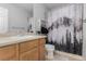 Neutral bathroom featuring a vanity, mirror and a mountain scene shower curtain at 16257 E 105Th Cir, Commerce City, CO 80022