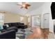 Spacious living room with a ceiling fan, wood flooring, and a cozy seating area with a dark gray sectional at 16257 E 105Th Cir, Commerce City, CO 80022