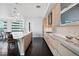 Modern kitchen with an island featuring barstool seating and light wood cabinets with views of the dining area at 2001 Lincoln St # 1811, Denver, CO 80202