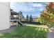 Well-manicured backyard with a covered deck, green grass, and mature trees at 9629 Silent Hills Ln, Lone Tree, CO 80124