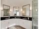Modern bathroom featuring dual sinks with black countertops, and large mirrors, complemented by a glass-enclosed shower at 9629 Silent Hills Ln, Lone Tree, CO 80124