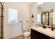 Cozy bathroom with tile shower, vanity, toilet, mirror, and a window, creating a bright and functional space at 9629 Silent Hills Ln, Lone Tree, CO 80124