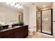 Modern bathroom with a glass shower, dark wood vanity, black countertop and fixtures, and tiled floors at 9629 Silent Hills Ln, Lone Tree, CO 80124