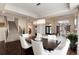 Formal dining area with statement chandelier, wood floors, large dining table, and adjacent living spaces at 9629 Silent Hills Ln, Lone Tree, CO 80124