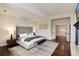 Bright main bedroom with a spacious layout, adjoining hallway, and hardwood floors at 9629 Silent Hills Ln, Lone Tree, CO 80124