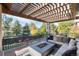 Inviting outdoor patio with fire pit and comfortable seating under a pergola at 9629 Silent Hills Ln, Lone Tree, CO 80124
