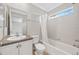 Bright bathroom with tiled shower/tub, vanity with large mirror, and a window for natural light at 7422 E 7Th Ave # 14, Denver, CO 80230