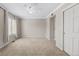 Spacious bedroom features neutral carpet, a ceiling fan, and a large window with window treatment at 7422 E 7Th Ave # 14, Denver, CO 80230
