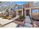 Charming brick townhomes featuring covered front porches, landscaping, and inviting entryways with steps leading to the front doors at 7422 E 7Th Ave # 14, Denver, CO 80230