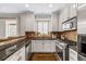 Modern kitchen with white cabinets, stainless steel appliances, granite countertops, tile backsplash, and hardwood flooring at 7422 E 7Th Ave # 14, Denver, CO 80230