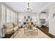 Elegant living room featuring a decorative chandelier, neutral paint, a window with shutters, and hardwood floors at 7422 E 7Th Ave # 14, Denver, CO 80230