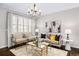 Elegant living room featuring a decorative chandelier, neutral paint, a window with shutters, and hardwood floors at 7422 E 7Th Ave # 14, Denver, CO 80230