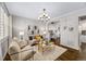 Elegant living room featuring hardwood floors, a chandelier, neutral paint, and view into a built-in office nook at 7422 E 7Th Ave # 14, Denver, CO 80230