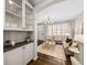 Open-concept living area with hardwood floors, white cabinetry, modern furniture, and natural light at 7422 E 7Th Ave # 14, Denver, CO 80230