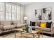 Bright living room features modern furniture, neutral decor, and natural light from shuttered windows at 7422 E 7Th Ave # 14, Denver, CO 80230