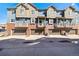 Townhome exterior featuring brick and siding, with private garages and small balconies at 7422 E 7Th Ave # 14, Denver, CO 80230