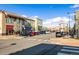 A well-maintained street scene in a town center with blooming trees and various shops visible at 7422 E 7Th Ave # 14, Denver, CO 80230