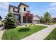 Charming two-story home featuring stone accents, a well-manicured lawn, and an attached two-car garage at 11898 Discovery Cir, Parker, CO 80138