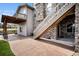 Back patio features an outdoor staircase, a textured stone patio, and a covered porch area at 11898 Discovery Cir, Parker, CO 80138