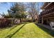 Large backyard with grassy area, mature trees, and deck at 7107 E Costilla Dr, Centennial, CO 80112