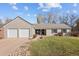 Inviting ranch-style home with a two-car garage, gray siding, tile roof, and a well-maintained front lawn at 7107 E Costilla Dr, Centennial, CO 80112