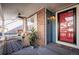 Inviting front porch with wicker seating, a ceiling fan, stylish rug, and a vibrant red front door with a 'Welcome' doormat at 9839 Foxhill Cir, Highlands Ranch, CO 80129