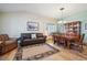 Cozy living room with hardwood floors, a plush leather sofa, an armchair, and a dining area with wood table and chairs at 9839 Foxhill Cir, Highlands Ranch, CO 80129