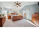 Spacious carpeted bedroom featuring a ceiling fan, vaulted ceiling, and natural lighting at 9839 Foxhill Cir, Highlands Ranch, CO 80129