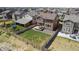Aerial view of a home showcasing a backyard with a wooden fence, green lawn, patio, and gravel area at 13221 E 110Th Pl, Commerce City, CO 80022